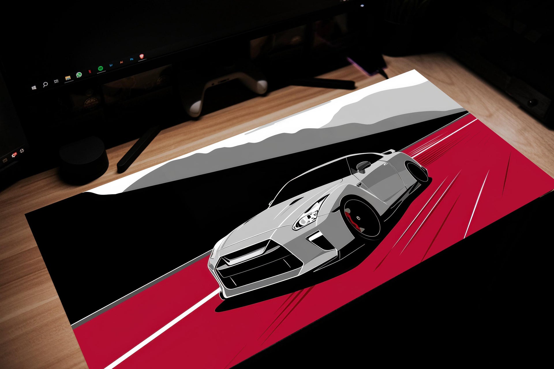 Car design on a desk mat with a computer setup in the background