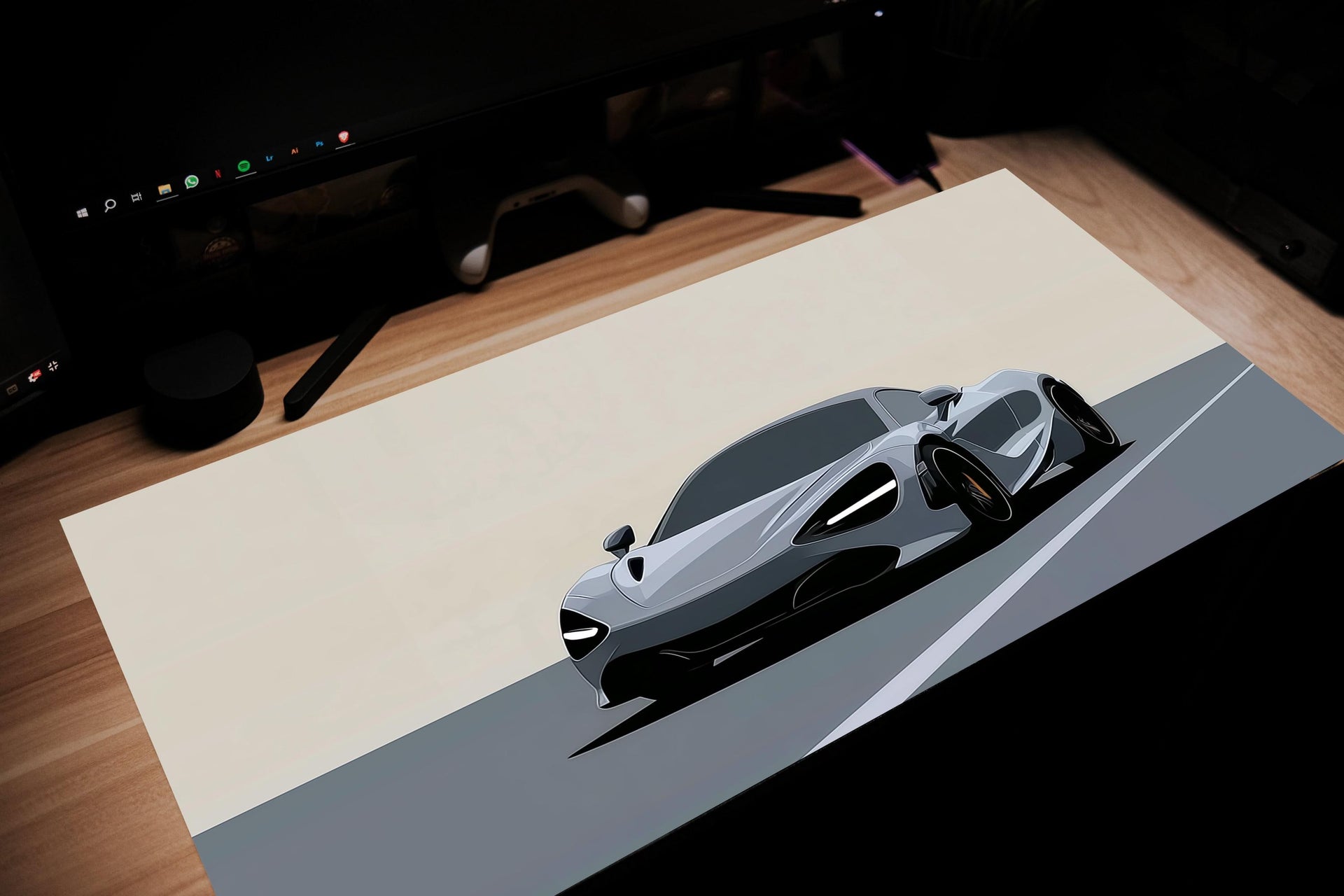 Modern sports car on a desk with a computer setup in the background